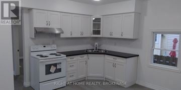 St. Catharines (Downtown) duplex for rent - A white stove and cabinets in a kitchen.