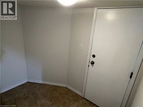 Kitchener apartment for rent - A white door with black handles is in a room with a carpeted floor.