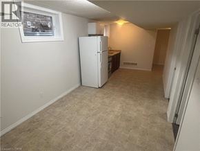 Kitchener apartment for rent - A white refrigerator in a room with beige carpeting.