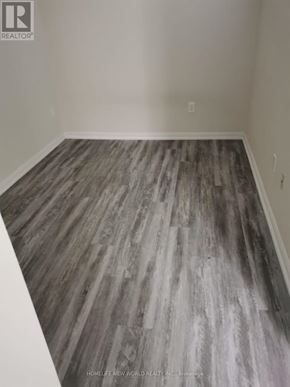 Toronto (Niagara) condo for rent - A room with a wooden floor and a logo that says "REALTOR" on the wall.