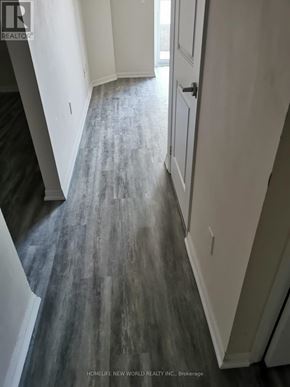 Toronto (Niagara) condo for rent - A hallway with a wooden floor and white walls.
