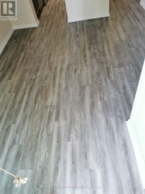 Toronto (Niagara) condo for rent - A grey wood floor in a room with a white door.
