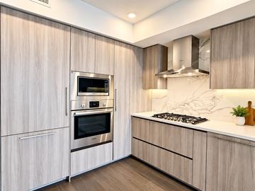 Surrey apartment for rent - A modern kitchen with a stainless steel oven and microwave built into the cabinetry.