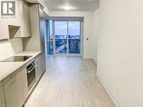 Mississauga condo for rent - A kitchen with white cabinets and a view of the city.