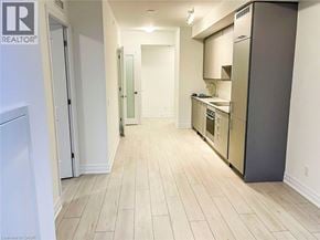 Mississauga condo for rent - A kitchen with a refrigerator, sink, and cabinets.