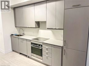 Mississauga condo for rent - A modern kitchen with white cabinets and stainless steel appliances.