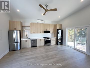 St. Catharines (Rykert/Vansickle) apartment for rent - A spacious kitchen with wooden cabinets and a stainless steel refrigerator.