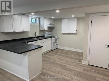 London East (East I) duplex for rent - A kitchen with white cabinets and a black countertop.