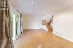 Mississauga (Meadowvale) townhouse for rent - A spacious room with wooden floors and a curved staircase.