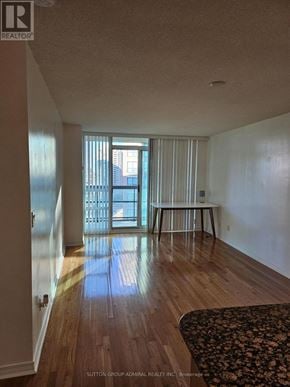 Toronto (Willowdale West) condo for rent - A room with wooden floors and a large window with blinds.