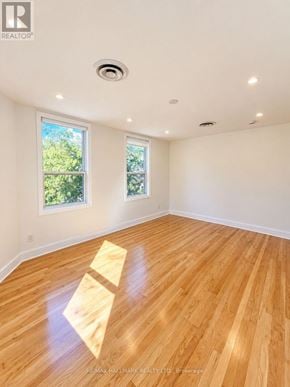 Toronto (South Riverdale) apartment for rent - A room with wooden flooring and two windows.