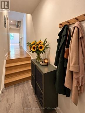 Toronto (South Riverdale) apartment for rent - A hallway with a vase of sunflowers on a table and coats hanging on a rack.