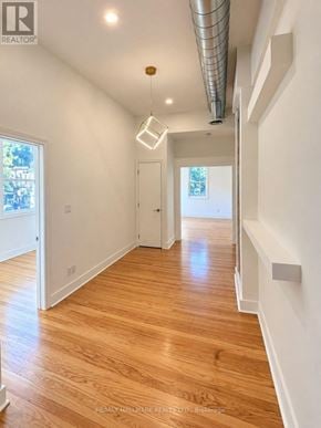 Toronto (South Riverdale) apartment for rent - A long hallway with wood floors and white walls.