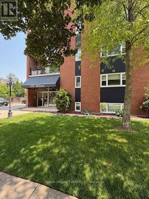 London East (East F) condo for rent - A brick building with a green lawn in front.