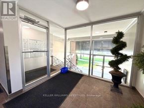 London East (East F) condo for rent - A realtor sign is on the wall in a room with a sliding glass door.