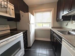 London East (East F) condo for rent - A kitchen with black cabinets and a white refrigerator.