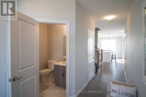 London North (North I) townhouse for rent - A bathroom with a toilet, sink, and a door leading to another room.