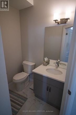 London North (North I) townhouse for rent - A bathroom with a toilet, sink, and mirror.