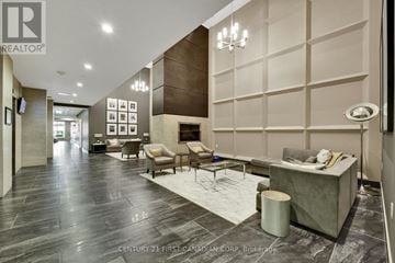 London East (East K) condo for rent - A modern living room with a grey sofa and a fireplace.