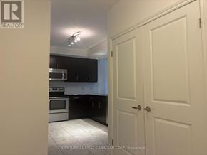 London East (East K) condo for rent - A kitchen with white cabinets and black countertops.