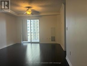 London East (East K) condo for rent - A spacious room with a ceiling fan and sliding glass doors leading to a balcony.