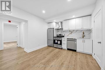 Toronto (Kensington-Chinatown) apartment for rent - A kitchen with white cabinets and a wooden floor.