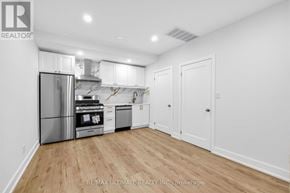 Toronto (Kensington-Chinatown) apartment for rent - A kitchen with white cabinets and a stainless steel refrigerator.