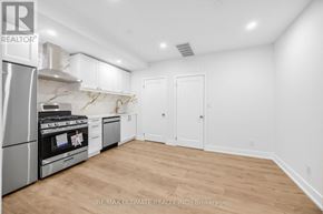 Toronto (Kensington-Chinatown) apartment for rent - A kitchen with white cabinets and a stainless steel refrigerator.