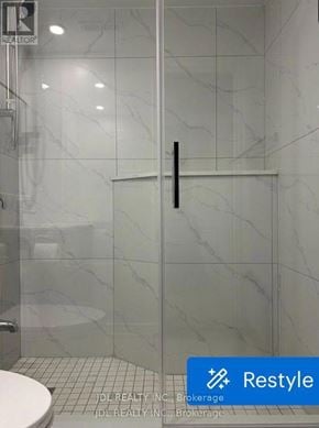 Toronto (Pleasant View) apartment for rent - A white toilet sits in a bathroom with a marble wall and a glass door.