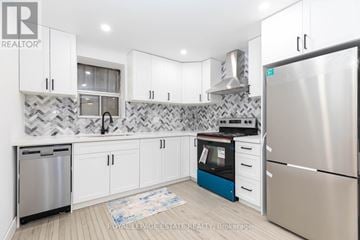 Toronto (The Beaches) multi-family for rent - A kitchen with white cabinets and a patterned backsplash.