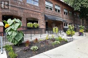 Toronto (Dovercourt-Wallace Emerson-Junction) condo for rent - A brick building with a flower garden in front.