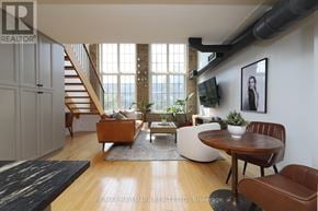 Toronto (Dovercourt-Wallace Emerson-Junction) condo for rent - A living room with a brown leather chair and a wooden table.