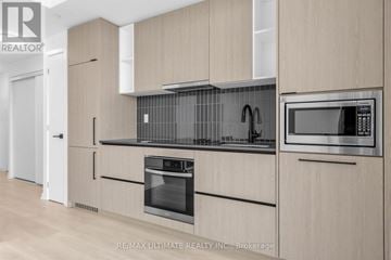 Toronto (Dovercourt-Wallace Emerson-Junction) condo for rent - A modern kitchen with wooden cabinets and stainless steel appliances.