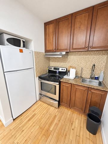 Montréal apartment for rent - A kitchen with wooden cabinets and a white fridge.