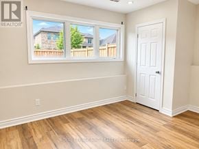 Orillia apartment for rent - A room with a white door and a window showing a view of a house and a fence.