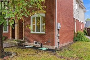 Oakville (Wt West Oak Trails) townhouse for rent - A red brick house with a white window and a tree in front.