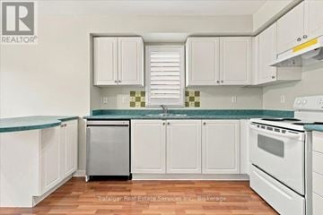 Oakville (Wt West Oak Trails) townhouse for rent - A kitchen with white cabinets and a green countertop.