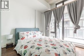 Toronto (Waterfront Communities) condo for rent - A bedroom with a large bed and a window with curtains.