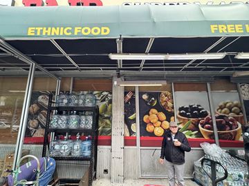 Astoria apartment for rent - A storefront with a green awning advertising ethnic food.
