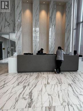 Mississauga (City Centre) condo for rent - A man is standing in front of a reception desk.