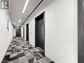 Toronto (Moss Park) condo for rent - A hallway with white brick walls and black and white checkered flooring.