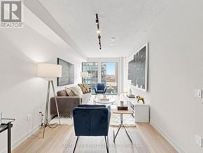 Toronto (Moss Park) condo for rent - A well-lit, modern living room with a view of the city.