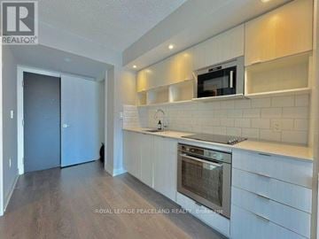 Toronto (Church-Yonge Corridor) condo for rent - A modern kitchen with white cabinets and a stainless steel oven.