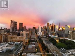 Toronto (Church-Yonge Corridor) condo for rent - A cityscape at dusk with the sun setting behind the buildings.