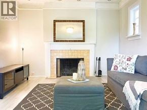 Vancouver apartment for rent - A living room with a grey couch and a fireplace.