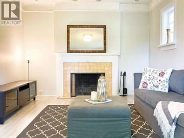 Vancouver apartment for rent - A living room with a grey couch and a fireplace.