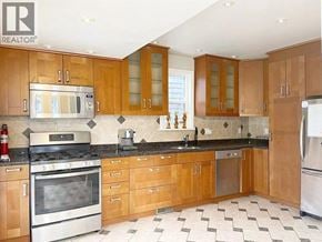 Vancouver apartment for rent - A kitchen with wooden cabinets and a black and white tiled floor.