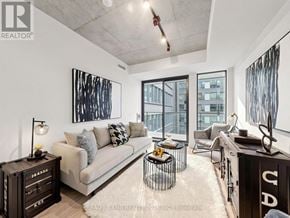 Toronto (Moss Park) condo for rent - A modern living room with a large window and a view of a building outside.