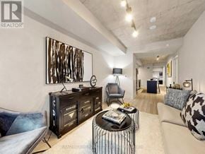 Toronto (Moss Park) condo for rent - A modern living room with a large painting on the wall and a black and white patterned couch.