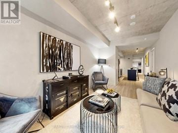 Toronto (Moss Park) condo for rent - A modern living room with a large painting on the wall and a black and white patterned couch.